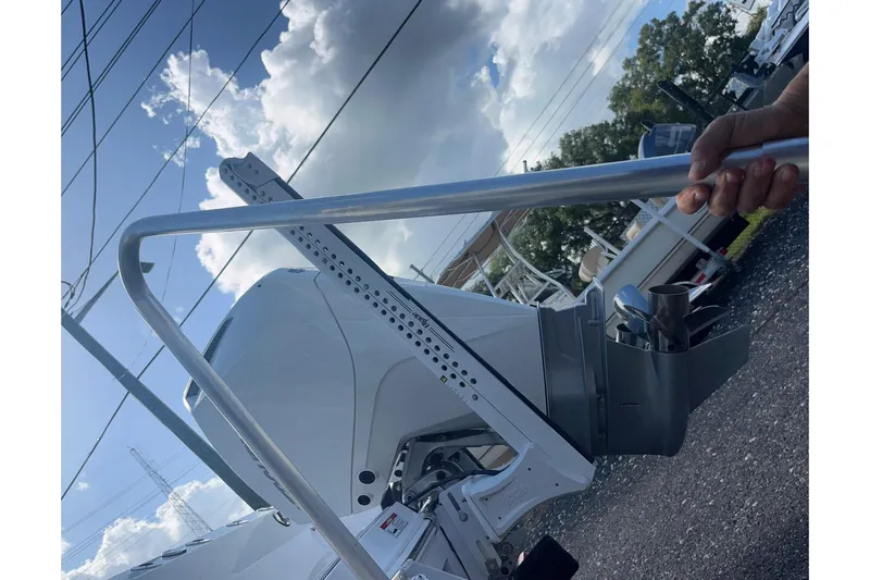 Slide: The Image of 2025 Blackfin 252 CC boat engine with a metal rod under a cloudy sky. - 19