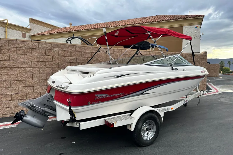 Slide: The Image of 2002 Chaparral 183 SS boat with red canopy on trailer, parked on roadside. - 2