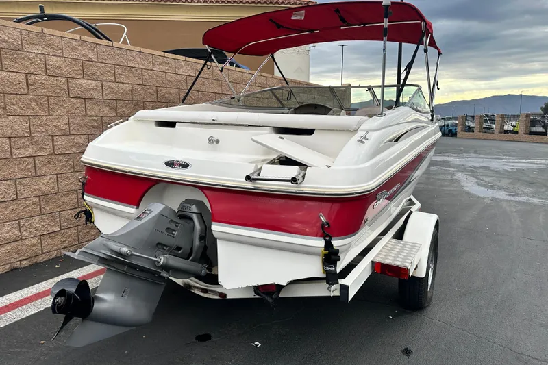 Slide: The Image of 2002 Chaparral 183 SS boat with red and white exterior, parked outdoors. - 3