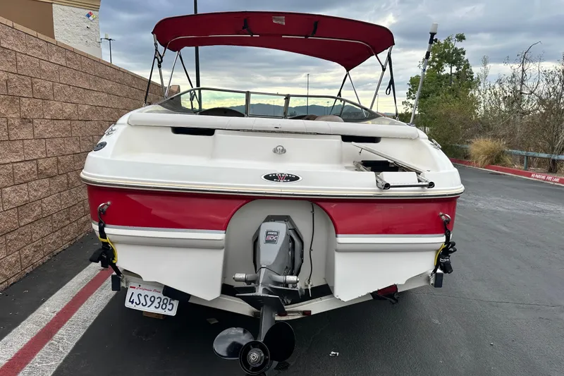 Slide: The Image of Chaparral 183 SS 2002 boat with red canopy on a trailer, parked outdoors. - 4
