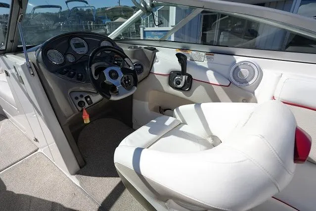 Slide: The Image of 2007 Rinker 226 Captiva Bowrider cockpit with steering wheel and white seating. - 10