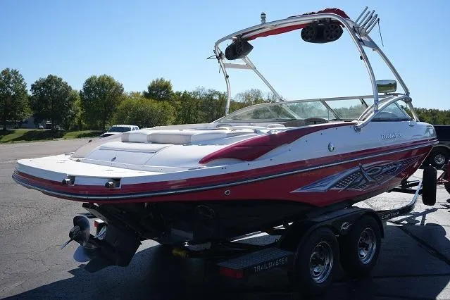 Slide: The Image of 2007 Rinker 226 Captiva Bowrider on trailer, red and white design, parked outdoors. - 3