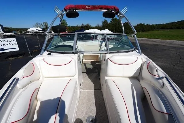 Slide: The Image of 2007 Rinker 226 Captiva Bowrider with white seating and red accents, parked outdoors. - 8
