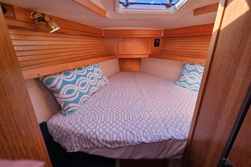 Slide: The Image of Cozy cabin interior of 2006 Catalina 400 MkII sailboat with patterned bedding and pillows. - 10