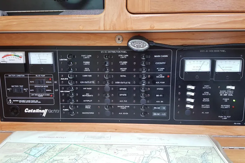Slide: The Image of Electrical control panel of a 2006 Catalina 400 MkII yacht with various switches and gauges. - 13