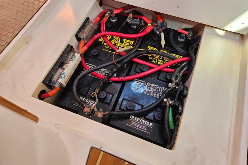 Slide: The Image of Deep cycle batteries in a 2006 Catalina 400 MkII sailboat, with red and black cables. - 19