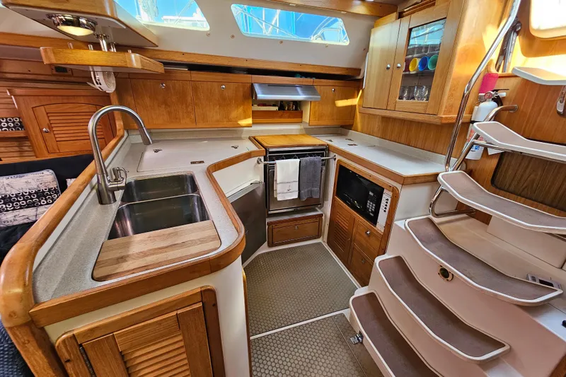 Slide: The Image of Interior of 2006 Catalina 400 MkII yacht kitchen with wooden cabinetry and modern appliances. - 9