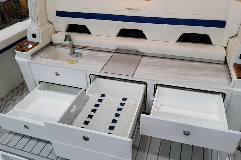 Slide: The Image of 2026 Formula 457 Center Console Fish boat with open storage drawers and sink. - 22