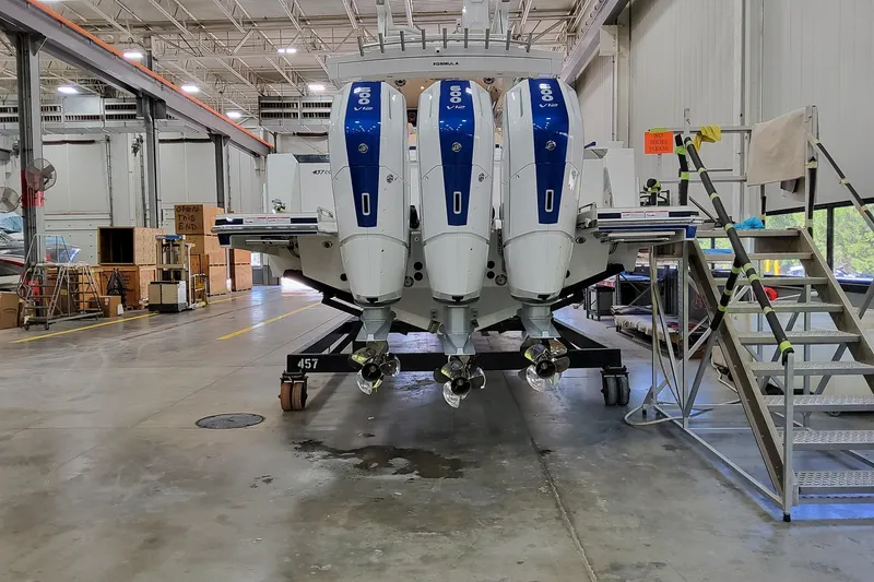 Slide: The Image of 2026 Formula 457 Center Console Fish boat in a warehouse with triple outboard engines. - 89