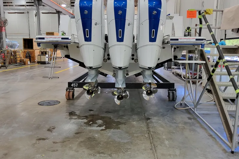 Slide: The Image of 2026 Formula 457 Center Console Fish boat in a workshop, showcasing triple outboard engines. - 92