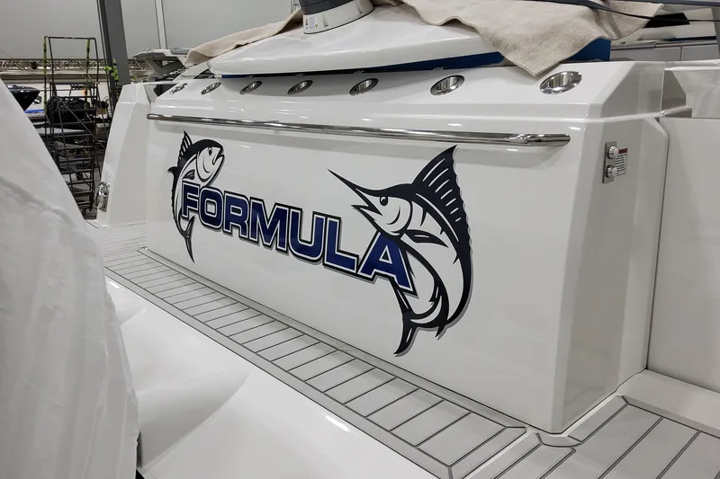Slide: The Image of 2026 Formula 457 Center Console Fish boat with marlin logo in a showroom. - 99