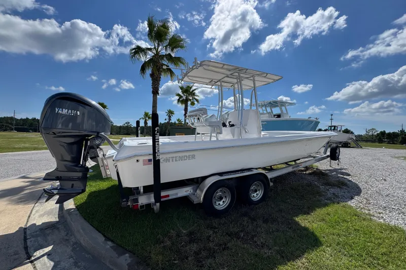 Slide: The Image of 2026 Contender 26 Bay boat on trailer with Yamaha engine, parked under blue sky. - 13