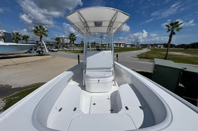 Slide: The Image of 2026 Contender 26 Bay boat with T-top, parked outdoors under a blue sky. - 19