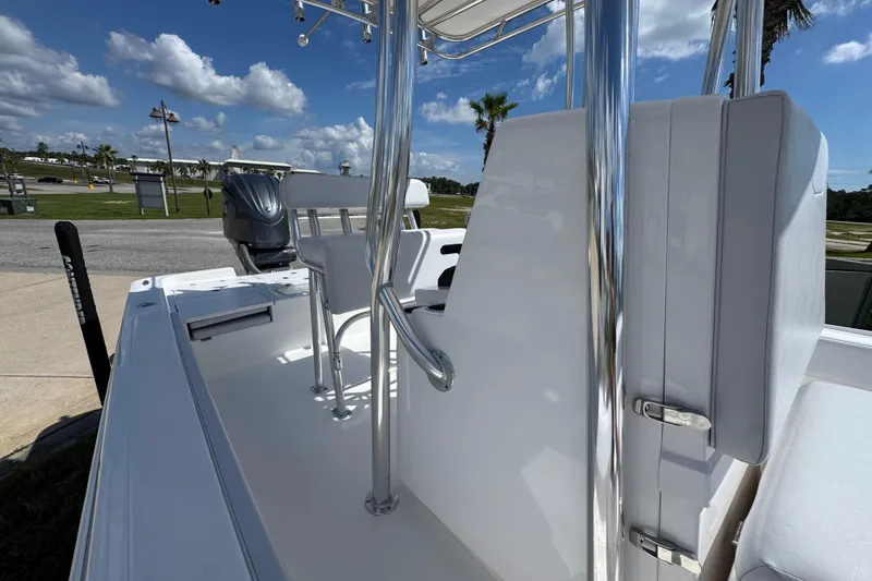 Slide: The Image of 2026 Contender 26 Bay boat interior with seating and chrome details under a blue sky. - 21