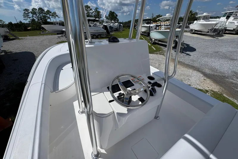 Slide: The Image of 2026 Contender 26 Bay boat with sleek console and steering wheel, parked outdoors. - 25