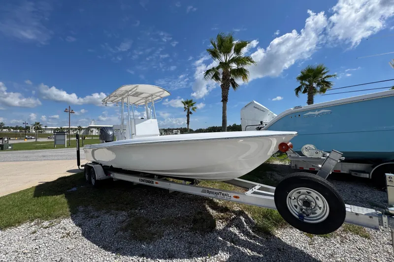 Slide: The Image of 2026 Contender 26 Bay boat on trailer under clear blue sky with palm trees. - 3
