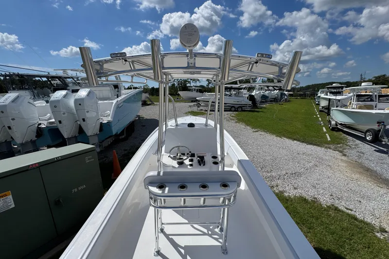 Slide: The Image of 2026 Contender 26 Bay boat with T-top, docked under a clear blue sky. - 32
