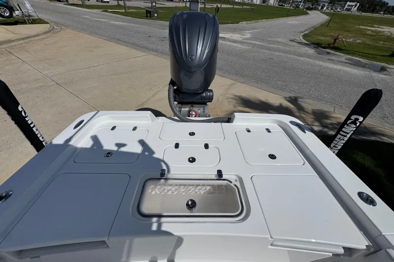 Slide: The Image of 2026 Contender 26 Bay boat with outboard motor, viewed from the rear on a sunny day. - 34