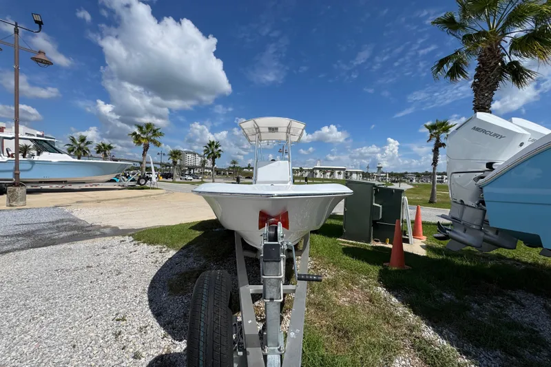 Slide: The Image of 2026 Contender 26 Bay boat on trailer, sunny day, palm trees, blue sky. - 5