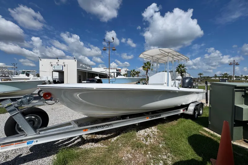 Slide: The Image of 2026 Contender 26 Bay boat on trailer under blue sky with clouds. - 7