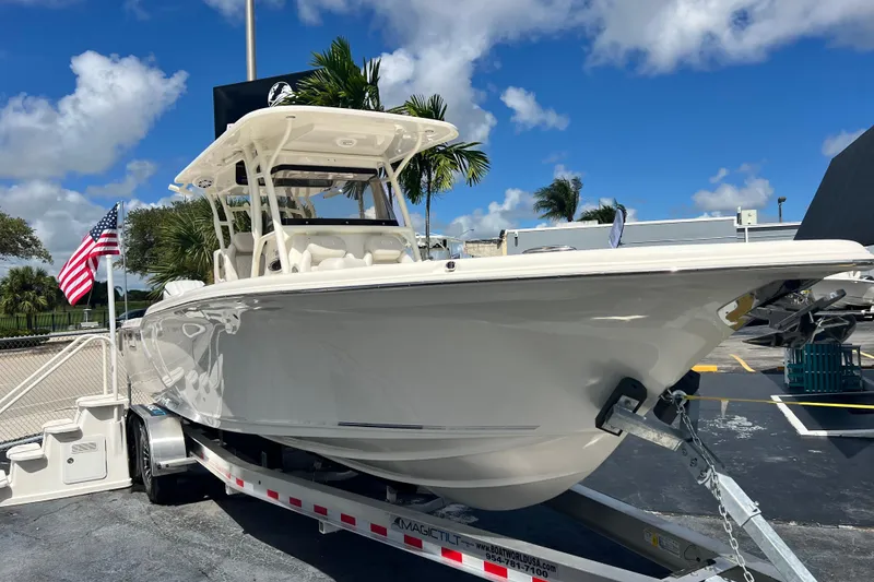 Slide: The Image of 2026 Key West 291 FS boat on trailer, sunny day, American flag nearby. - 2