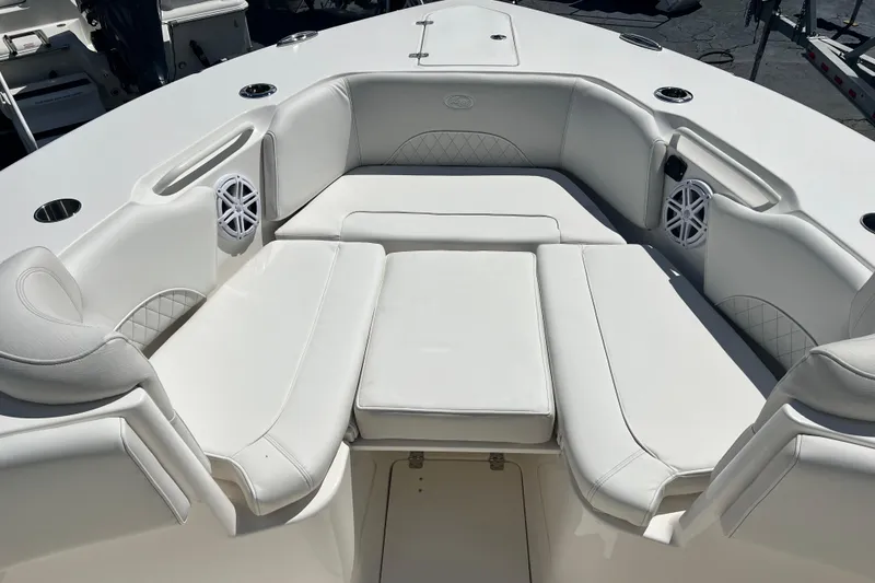 Slide: The Image of 2026 Key West 291 FS boat interior with white cushioned seating and speakers. - 27