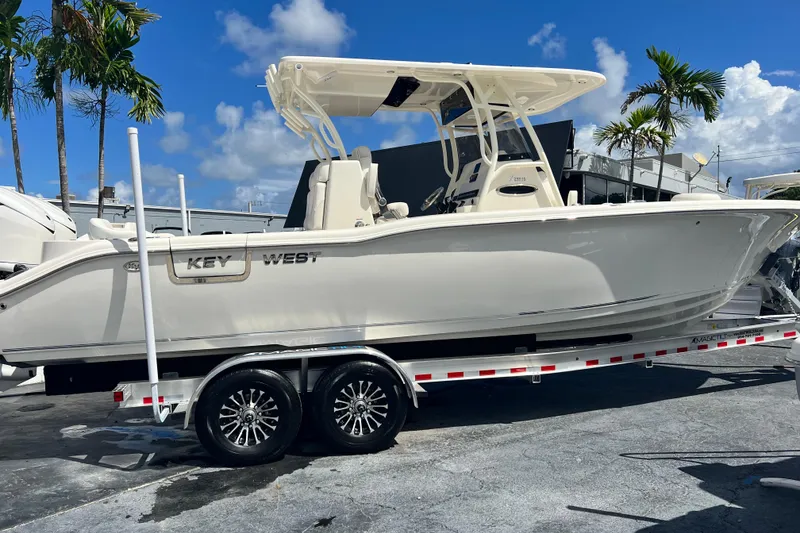 Slide: The Image of 2026 Key West 291 FS boat on trailer, parked outdoors under blue sky. - 3