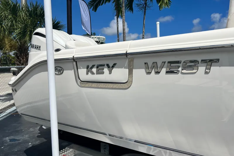 Slide: The Image of 2026 Key West 291 FS boat with Yamaha engine, displayed outdoors under palm trees. - 7