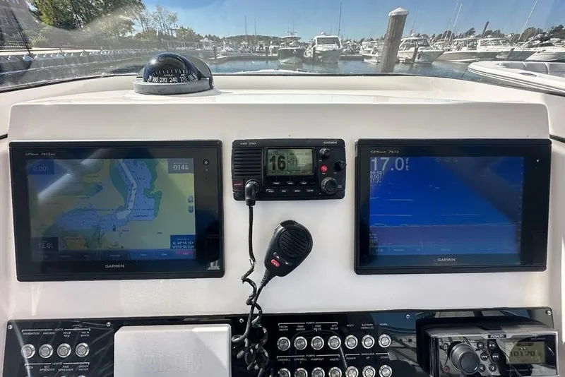 Slide: The Image of Dashboard of a 2015 Edgewater 320CC boat with Garmin navigation displays. - 10