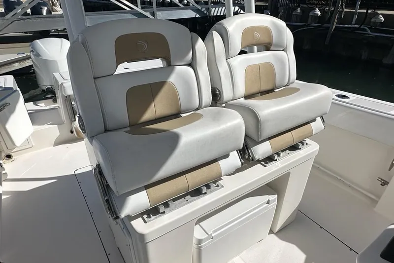 Slide: The Image of Luxury seating on 2015 Edgewater 320CC boat, featuring dual cushioned chairs. - 12