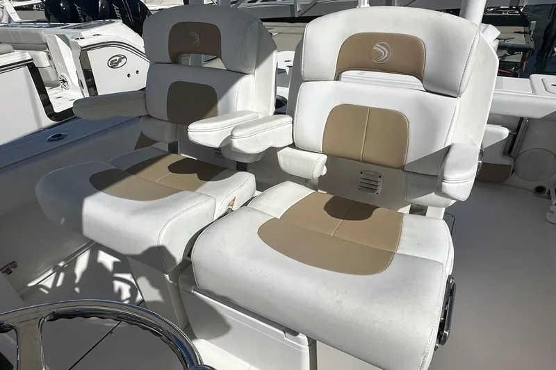 Slide: The Image of Two cushioned seats on a 2015 Edgewater 320CC boat, featuring armrests and beige accents. - 13