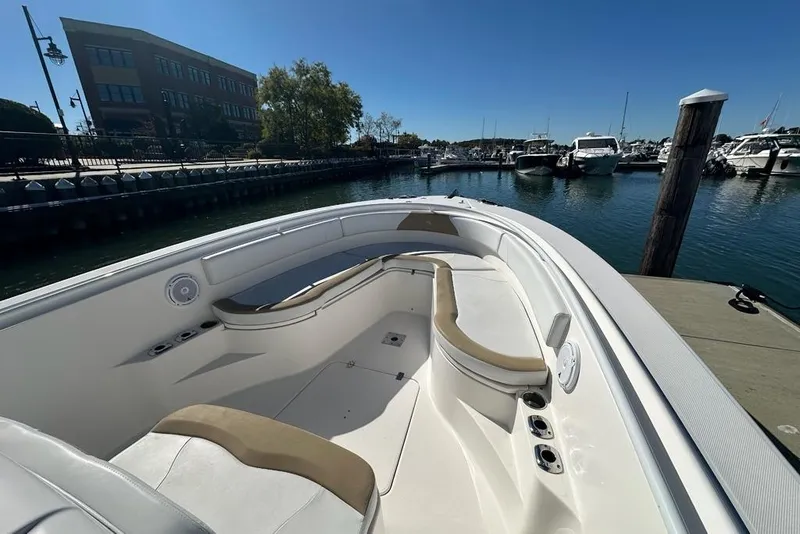 Slide: The Image of 2015 Edgewater 320CC boat docked at marina, featuring spacious seating and clear blue sky. - 17