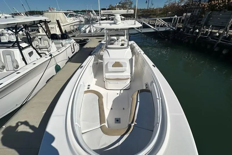 Slide: The Image of 2015 Edgewater 320CC boat docked at marina, featuring spacious deck and modern design. - 19