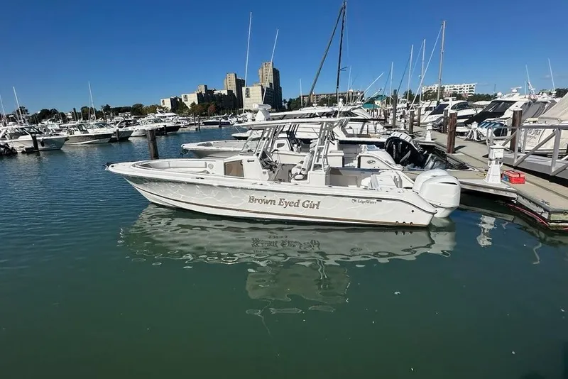 Slide: The Image of 2015 Edgewater 320CC boat named "Brown Eyed Girl" docked in a marina. - 2