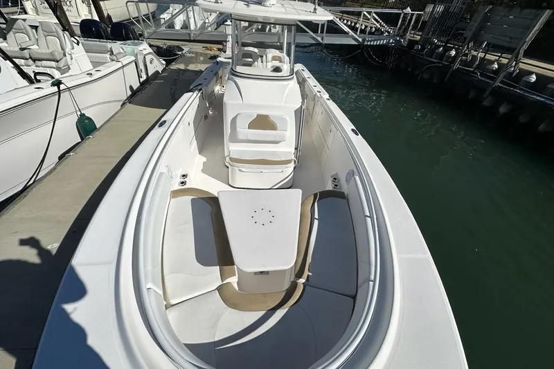 Slide: The Image of 2015 Edgewater 320CC boat docked, featuring spacious seating and sleek design. - 21