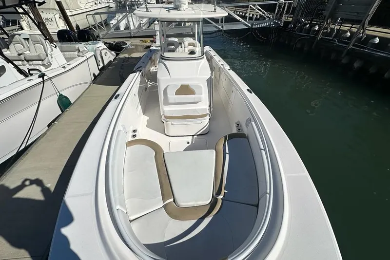 Slide: The Image of 2015 Edgewater 320CC boat docked, featuring spacious seating and sleek design. - 23