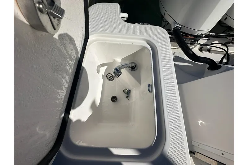 Slide: The Image of White sink on 2015 Edgewater 320CC boat, featuring faucet and drain. - 27