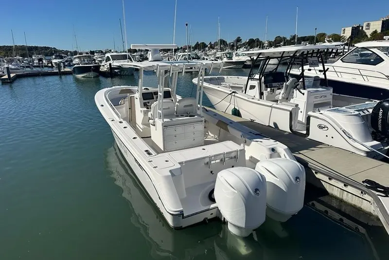 Slide: The Image of 2015 Edgewater 320CC boat docked at marina with twin engines. - 3
