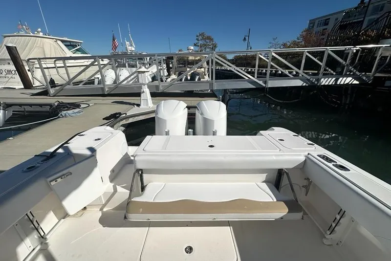 Slide: The Image of 2015 Edgewater 320CC boat docked at marina with dual engines and seating area. - 31