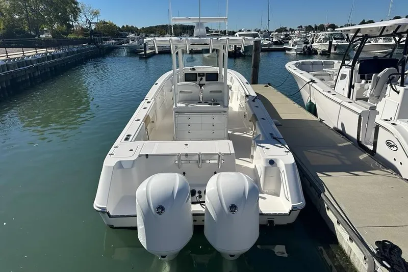 Slide: The Image of 2015 Edgewater 320CC boat docked at marina with twin engines. - 4