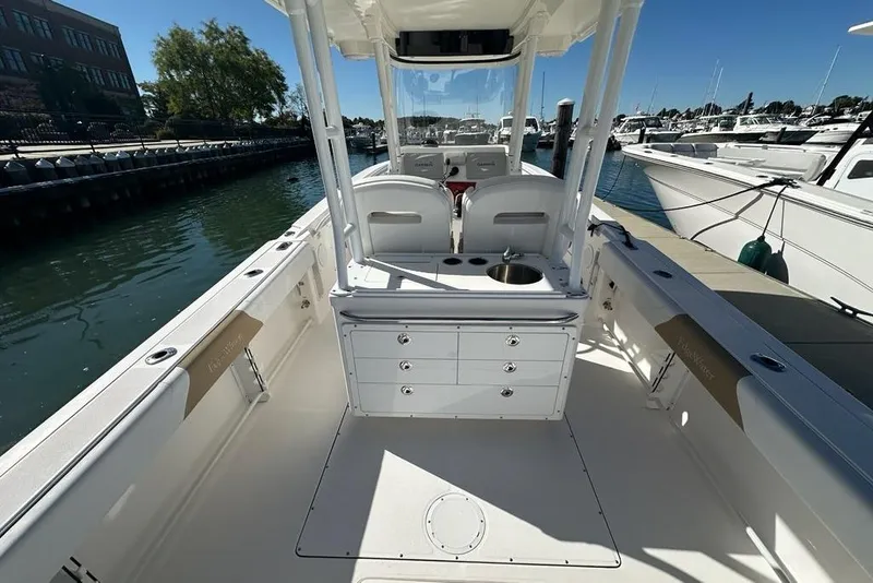 Slide: The Image of 2015 Edgewater 320CC boat interior, featuring seating and storage, docked at a marina. - 5