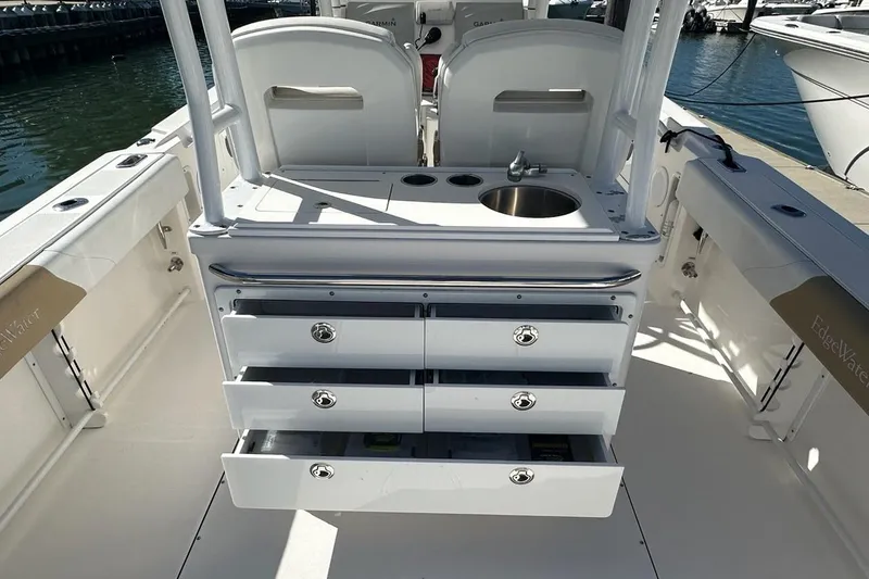 Slide: The Image of 2015 Edgewater 320CC boat interior with storage drawers and sink, docked at marina. - 6