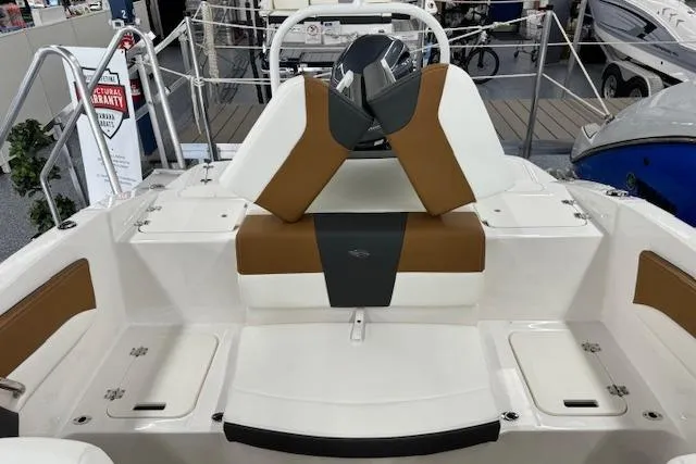 Slide: The Image of 2024 Chaparral 19 SSi OB boat interior with brown and white seating, showcasing modern design. - 12