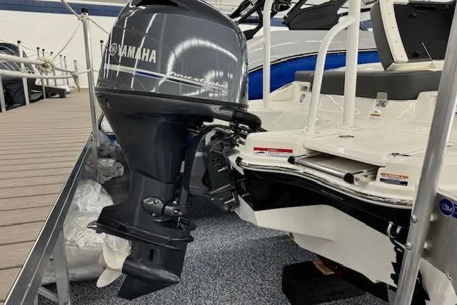 Slide: The Image of 2024 Chaparral 19 SSi OB boat with Yamaha outboard motor, docked indoors. - 19