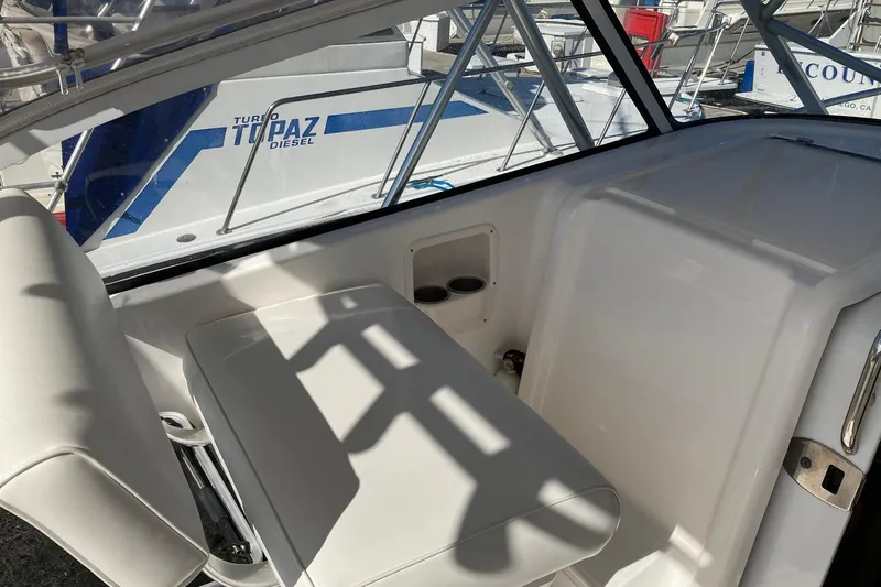 Slide: The Image of Interior of a 2006 Luhrs 28 boat, featuring white seating and window views. - 10