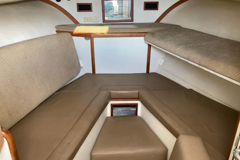 Slide: The Image of 2006 Luhrs 28 boat interior with cushioned seating and compact cabin layout. - 14