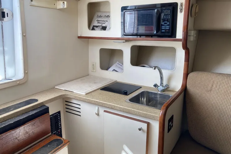 Slide: The Image of 2006 Luhrs 28 boat interior kitchen with microwave, sink, and stove. - 15