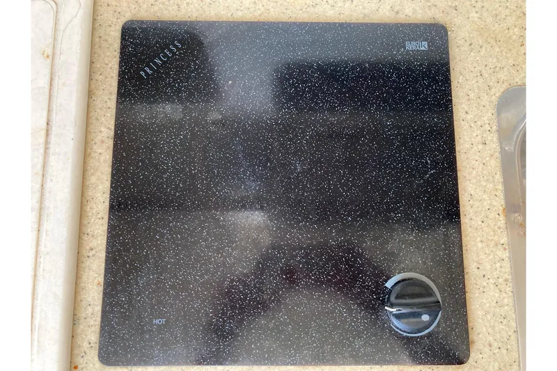 Slide: The Image of Black speckled cooktop on 2006 Luhrs 28 boat, featuring a single control knob. - 18