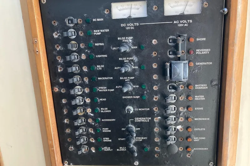 Slide: The Image of Electrical control panel on a 2006 Luhrs 28 boat, featuring various switches and meters. - 28