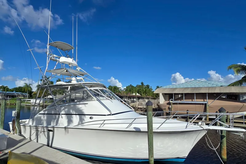 Slide: The Image of 1999 Ocean Yachts 40 Open docked under clear blue sky. - 10